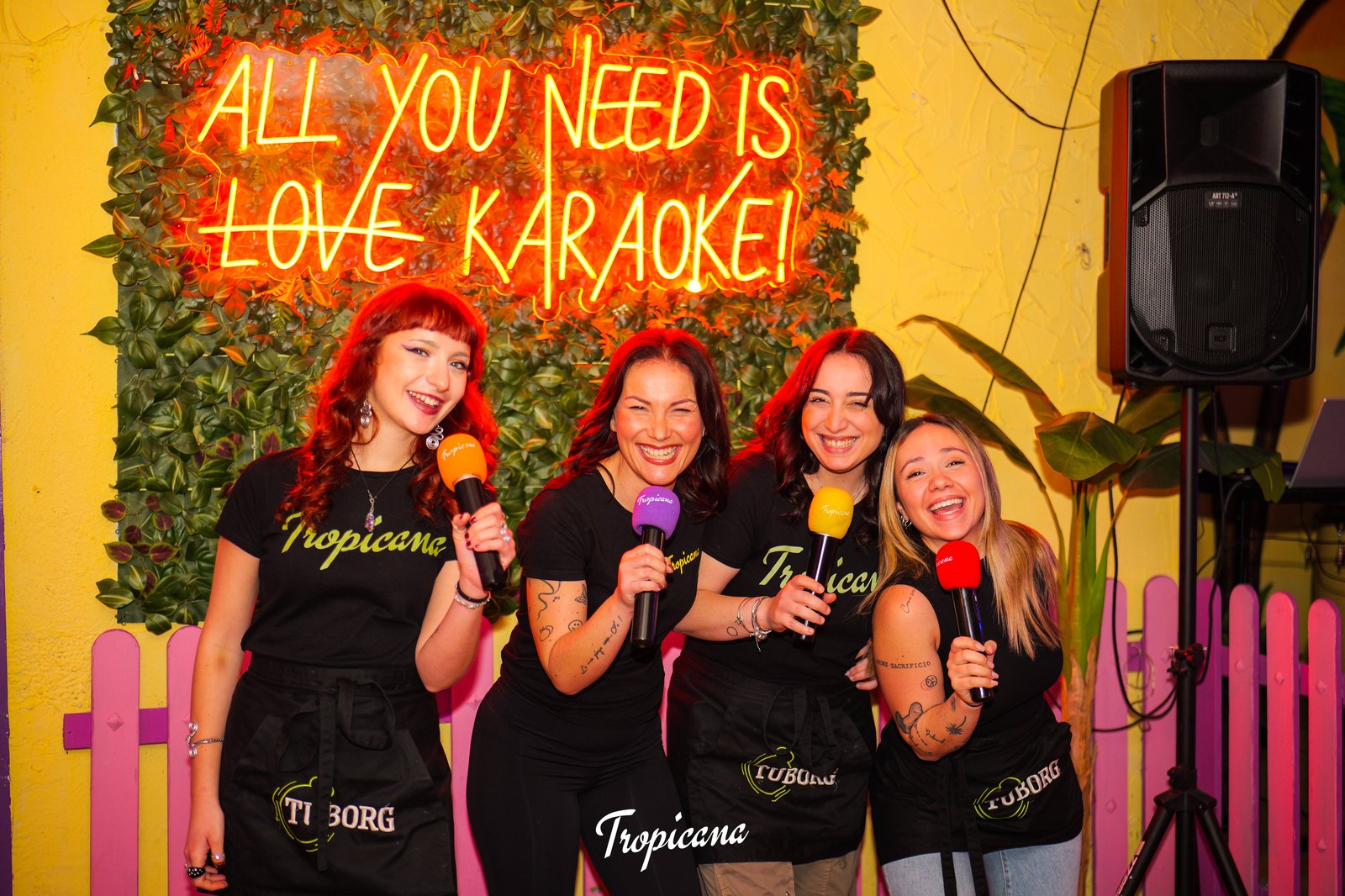 Staff del Tropicana con i microfoni sotto l'insegna al neon dedicata al karaoke
